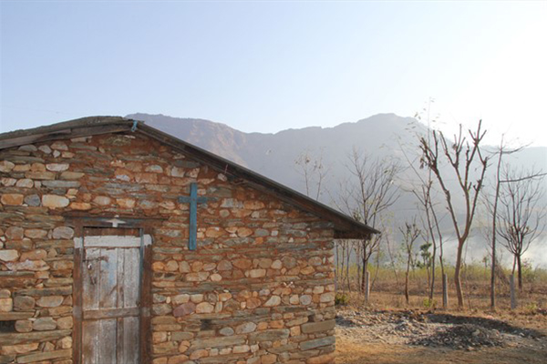 Shack in mountains with crucifix