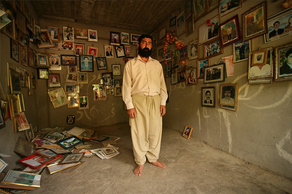 Middle Eastern man in room of photos